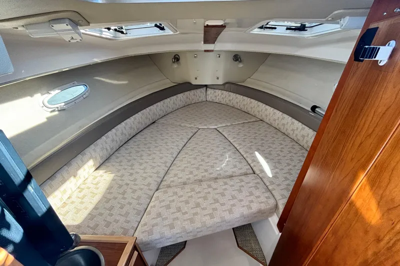  Yacht Photos Pics 2024 Cutwater C-248 Coupe interior cabin with cushioned seating and wooden accents.