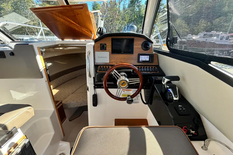  Yacht Photos Pics 2024 Cutwater C-248 Coupe interior with steering wheel, Garmin display, and cabin seating.