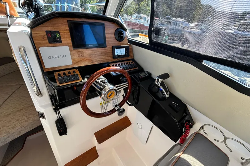  Yacht Photos Pics 2024 Cutwater C-248 Coupe helm with Garmin navigation, wooden steering wheel, and control panel.