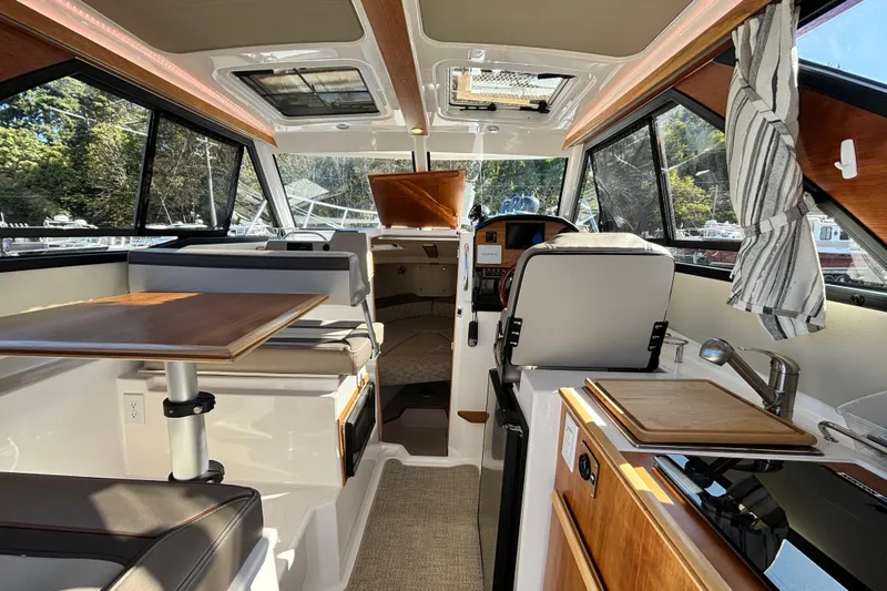  Yacht Photos Pics 2024 Cutwater C-248 Coupe interior with modern seating, table, and kitchenette.