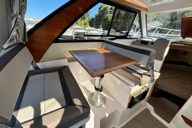  Yacht Photos Pics 2024 Cutwater C-248 Coupe interior with seating and wooden table, showcasing modern design.