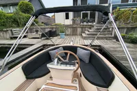 Custom Espevear 27 open boat, 2009 model, docked near a modern house with wooden deck.