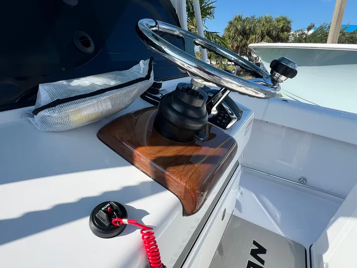  Yacht Photos Pics Steering wheel of 2025 Sportsman 352 Open boat with wooden accents and control panel.
