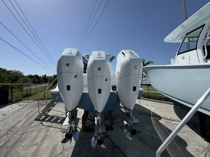  Yacht Photos Pics 2025 Sportsman 352 Open boat with triple outboard engines in a sunny outdoor setting.