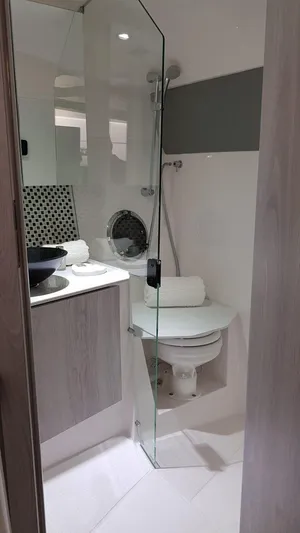 Custom Order Your 355 Today! Yacht Photos Pics Modern bathroom in 2025 Hanover 355 Outboard boat with glass shower and sleek fixtures.