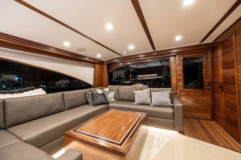 Boujie Yacht Photos Pics Luxurious interior of 2025 Viking 82 Convertible yacht with elegant wood finishes and plush seating.