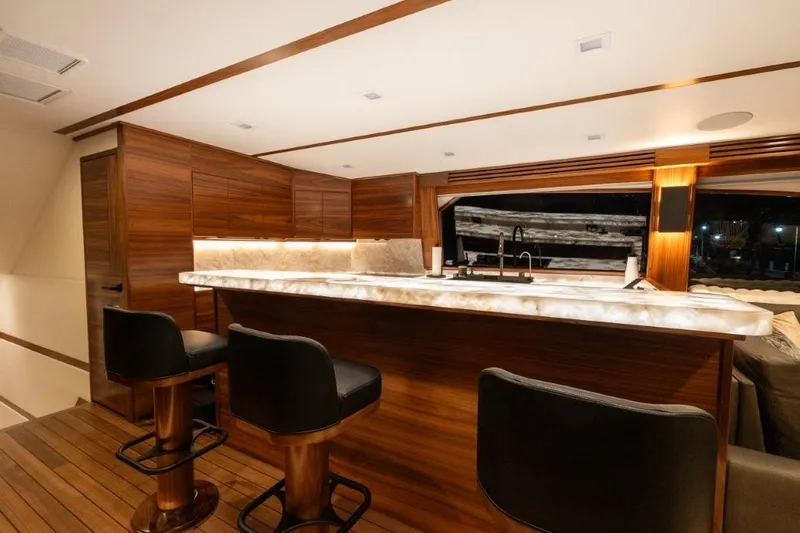 Boujie Yacht Photos Pics Luxurious interior of 2025 Viking 82 Convertible yacht with elegant bar and seating.