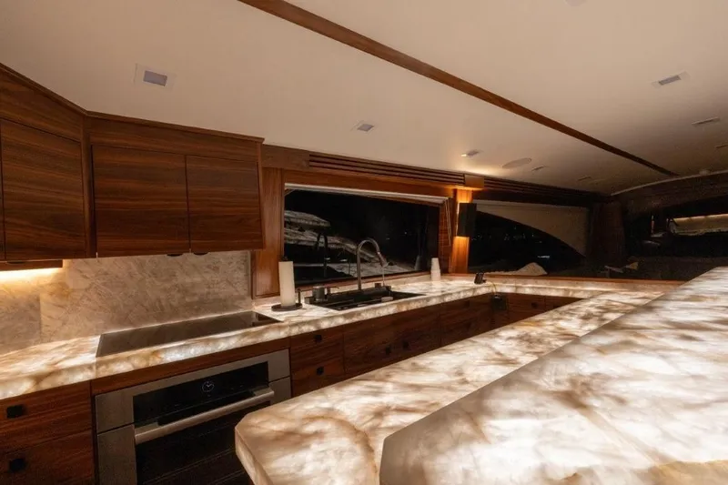 Boujie Yacht Photos Pics Luxurious kitchen interior of 2025 Viking 82 Convertible yacht with elegant wood cabinetry.