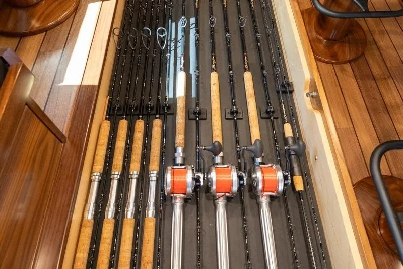 Boujie Yacht Photos Pics Fishing rods neatly stored on a 2025 Viking 82 Convertible yacht's wooden deck.
