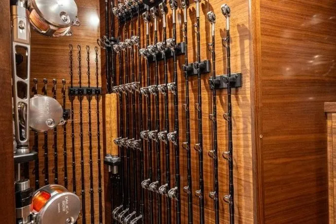 Boujie Yacht Photos Pics Fishing rods neatly stored in a 2025 Viking 82 Convertible yacht's wooden interior.