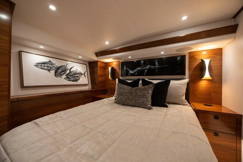 Boujie Yacht Photos Pics Luxurious bedroom interior of 2025 Viking 82 Convertible yacht with elegant wood finishes.