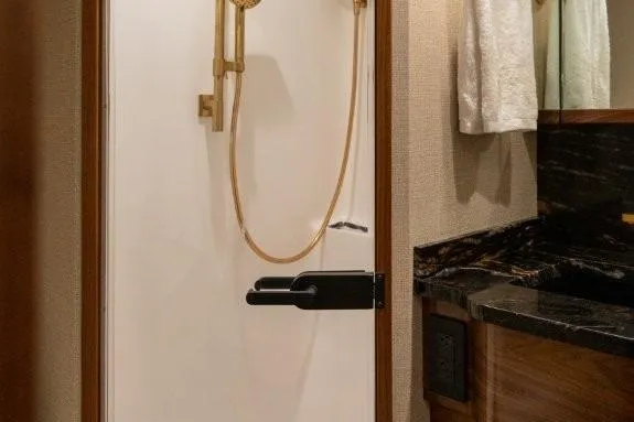 Boujie Yacht Photos Pics Luxurious bathroom in 2025 Viking 82 Convertible yacht with elegant gold fixtures.