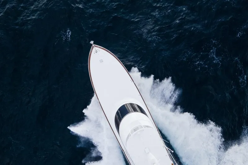 Boujie Yacht Photos Pics 2025 Viking 82 Convertible yacht cruising through ocean waves, aerial view.