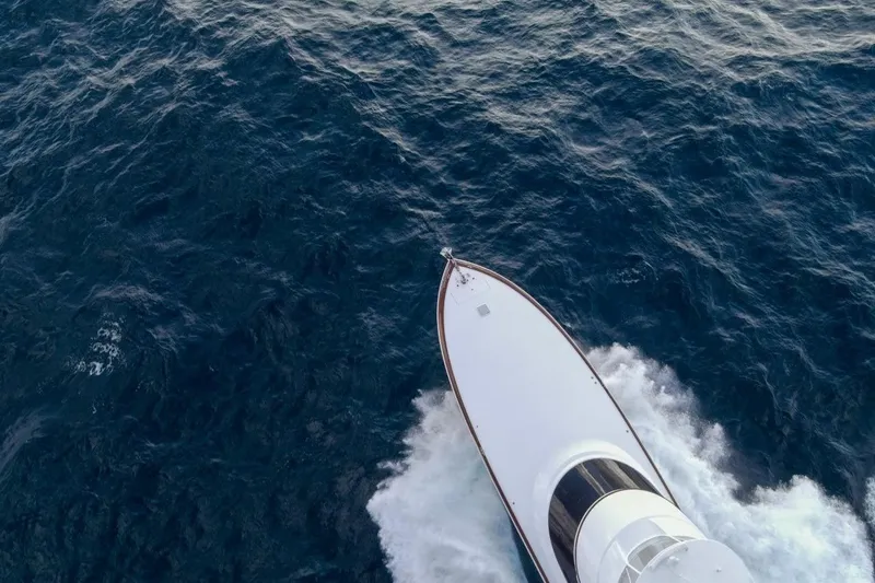 Boujie Yacht Photos Pics Aerial view of 2025 Viking 82 Convertible yacht cruising through deep blue ocean waters.