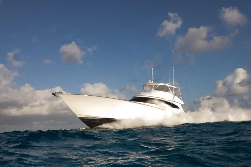 Boujie Yacht Photos Pics 2025 Viking 82 Convertible yacht cruising on open ocean under cloudy sky.