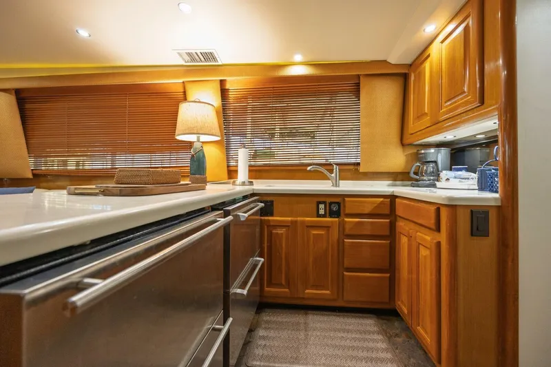 Miss Scarlett Yacht Photos Pics Luxurious kitchen interior of 1998 Viking 50 Convertible yacht with wooden cabinets.