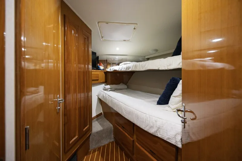 Miss Scarlett Yacht Photos Pics Cozy cabin interior of 1998 Viking 50 Convertible yacht with wooden finishes and bunk beds.