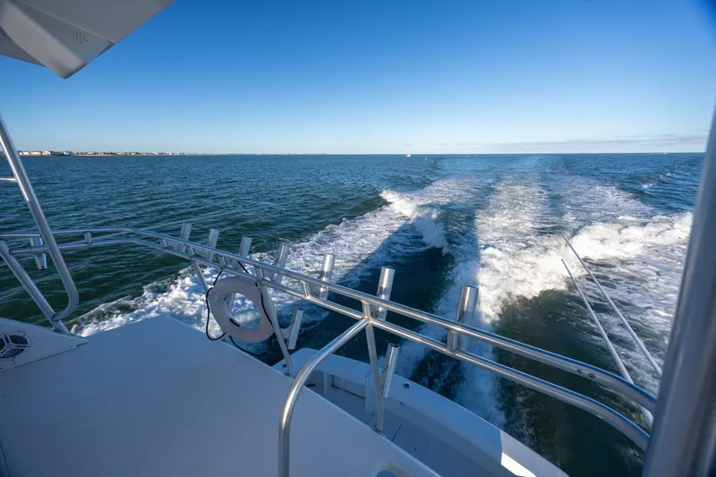 Miss Scarlett Yacht Photos Pics 1998 Viking 50 Convertible yacht cruising on open sea under clear blue sky.