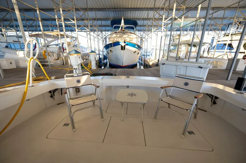 Miss Scarlett Yacht Photos Pics 1998 Viking 50 Convertible yacht docked, featuring deck chairs and a table in a marina.