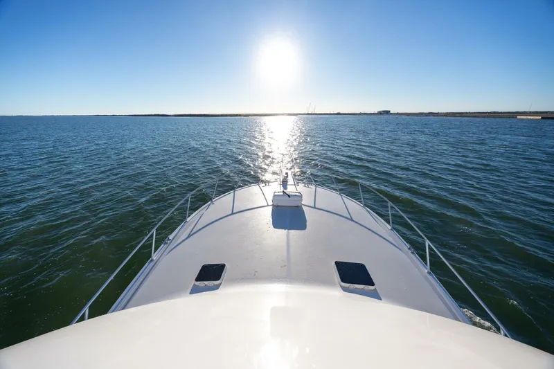 Miss Scarlett Yacht Photos Pics Bow of 1998 Viking 50 Convertible yacht cruising on open water under bright sun.