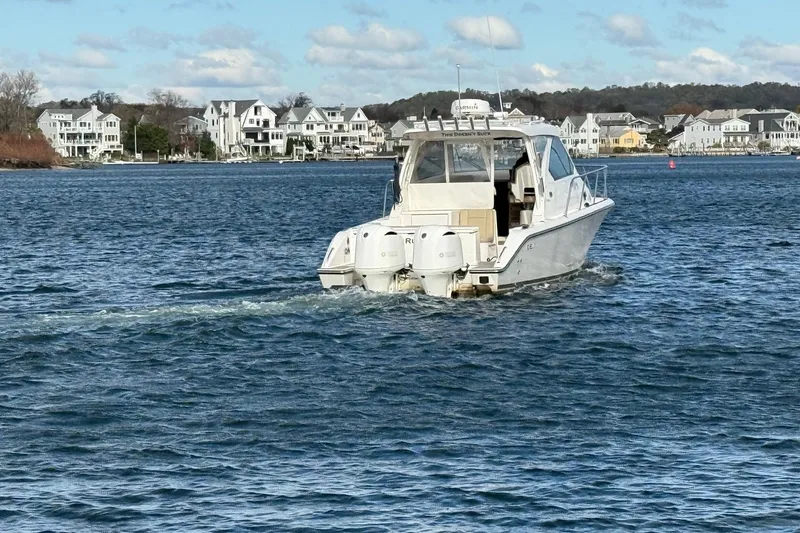  Yacht Photos Pics 2017 Pursuit OS 325 Offshore boat cruising near coastal homes.
