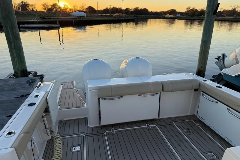  Yacht Photos Pics 2017 Pursuit OS 325 Offshore boat docked at sunset, featuring dual engines and spacious deck.