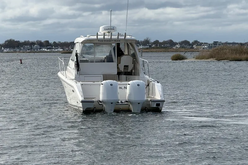  Yacht Photos Pics 2017 Pursuit OS 325 Offshore boat on calm water, rear view with twin engines.