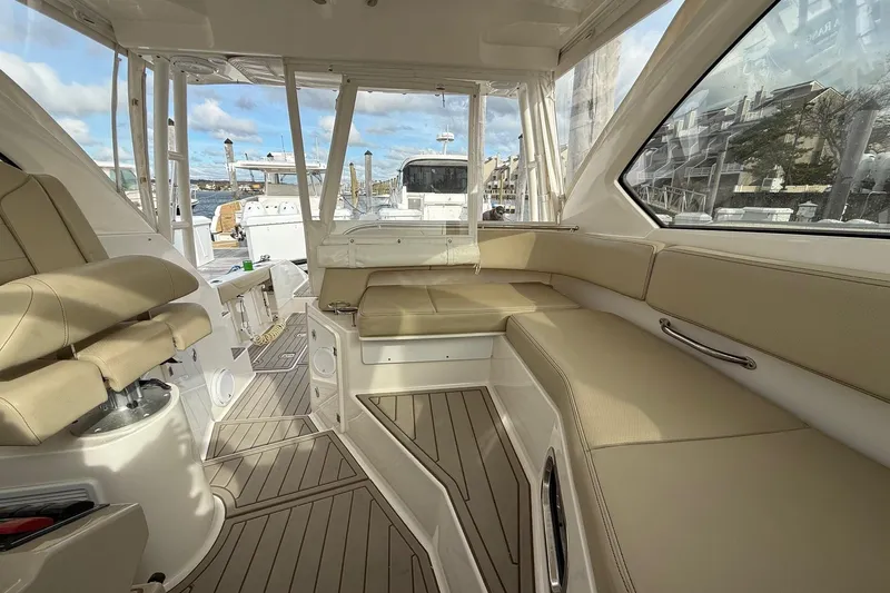  Yacht Photos Pics 2017 Pursuit OS 325 Offshore boat interior with beige seating and wood flooring.