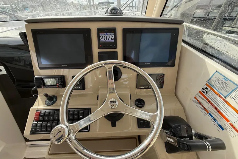  Yacht Photos Pics 2017 Pursuit OS 325 Offshore helm with dual Garmin displays and steering wheel.
