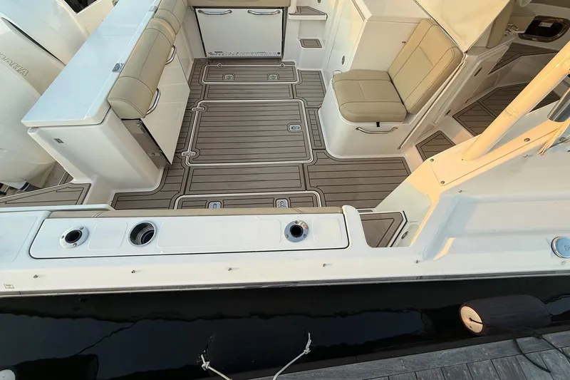  Yacht Photos Pics 2017 Pursuit OS 325 Offshore boat interior with cushioned seating and sleek deck design.