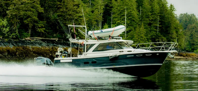  Yacht Photos Pics 2022 Cutwater C32 Northwest Edition cruising in a scenic forested waterway.