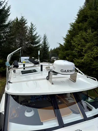  Yacht Photos Pics 2022 Cutwater C32 Northwest Edition boat with Garmin radar, surrounded by trees.