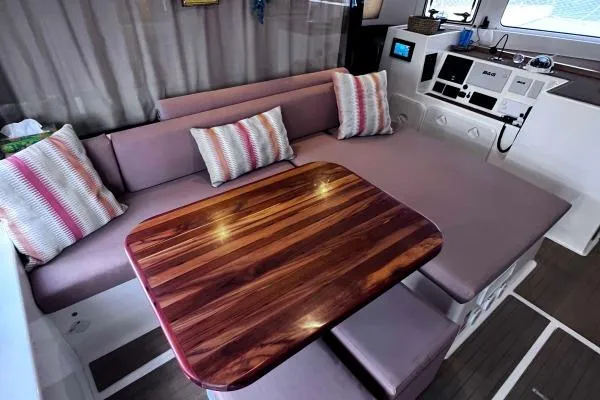 Meraki Yacht Photos Pics Luxurious interior of 2022 NEEL 43 yacht with plush seating and wooden table.