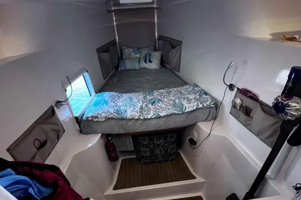 Meraki Yacht Photos Pics Cozy cabin interior of 2022 NEEL 43 trimaran with bed and storage compartments.