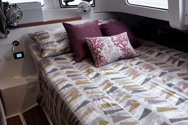 Meraki Yacht Photos Pics Cozy bedroom in 2022 NEEL 43 model, featuring patterned bedding and decorative pillows.