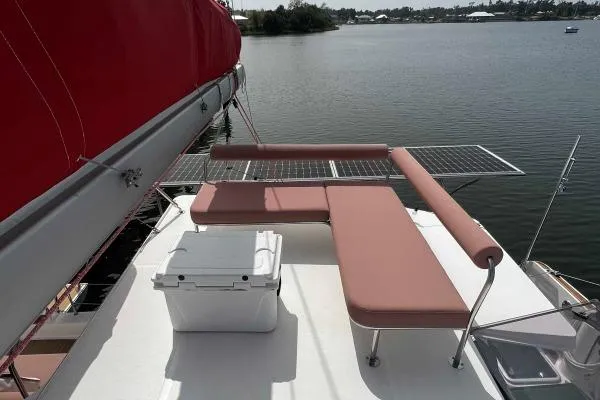 Meraki Yacht Photos Pics Tri-deck NEEL 43 sailboat with red sail, featuring a sunbathing area and cooler, 2022 model.