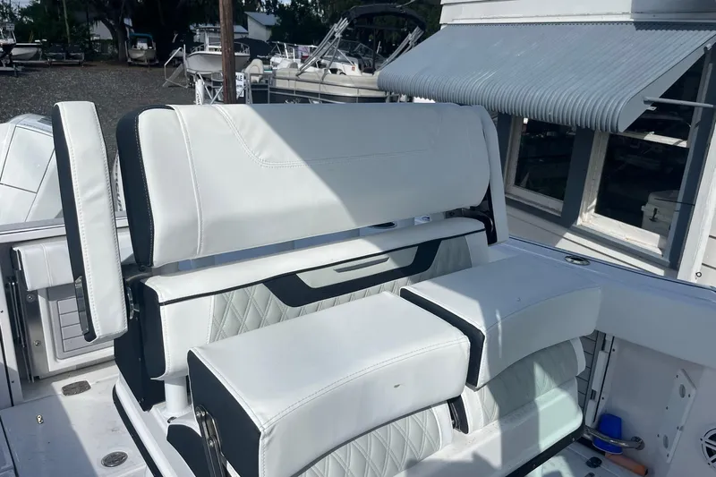 Yacht Photos Pics 2025 Blackfin 252 CC boat with white cushioned seating and armrests.