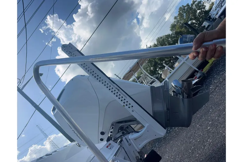  Yacht Photos Pics 2025 Blackfin 252 CC boat engine with a metal rod under a cloudy sky.