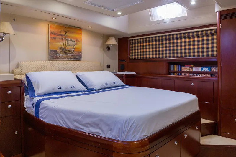 Cygnus Of Anglesey Yacht Photos Pics Luxurious bedroom interior of 2004 Oyster 82 yacht with elegant wood finish and cozy bedding.