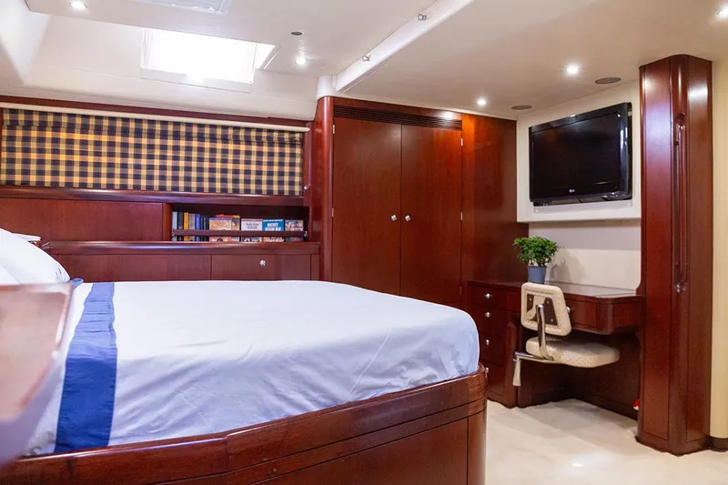 Cygnus Of Anglesey Yacht Photos Pics Luxurious cabin interior of 2004 Oyster 82 yacht with bed, TV, and desk.