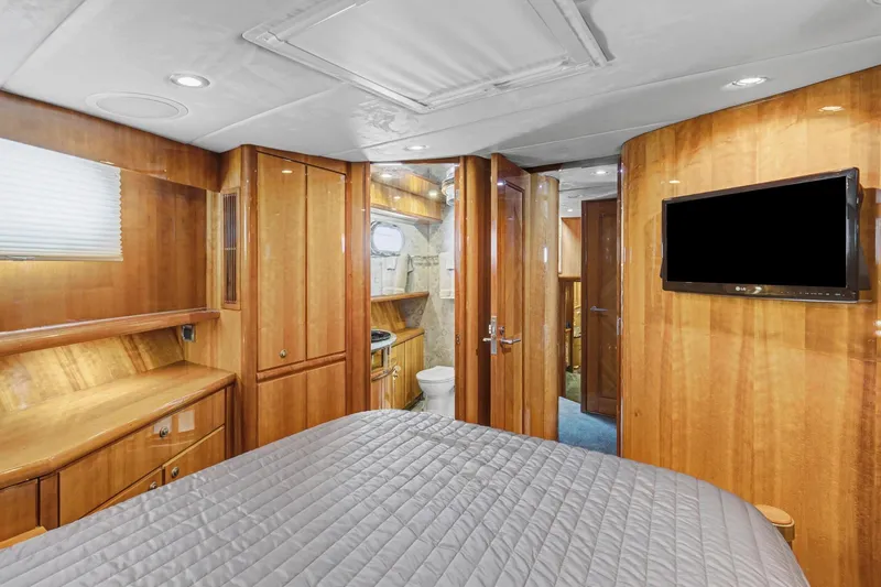  Yacht Photos Pics Luxurious cabin interior of 2004 Queenship 76 Baretta yacht with wood finish and modern amenities.
