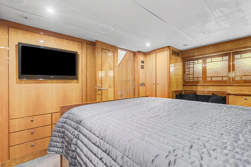  Yacht Photos Pics Luxurious 2004 Queenship 76 Baretta yacht bedroom with wood paneling and modern amenities.