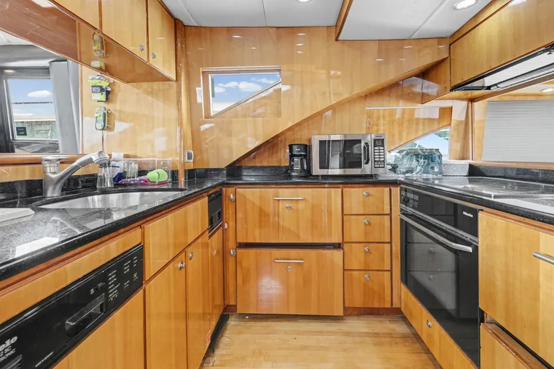  Yacht Photos Pics Luxurious kitchen interior of 2004 Queenship 76 Baretta yacht with modern appliances and wood cabinetry.