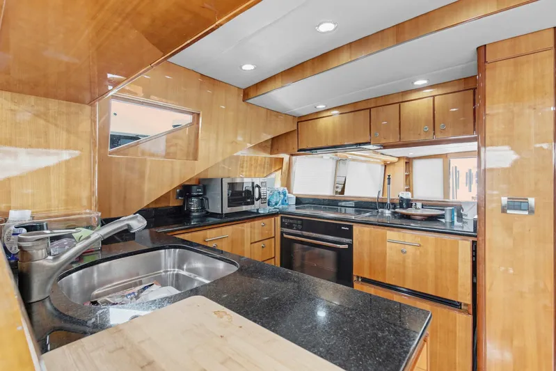  Yacht Photos Pics Luxurious kitchen interior of 2004 Queenship 76 Baretta yacht with modern appliances and wood finish.