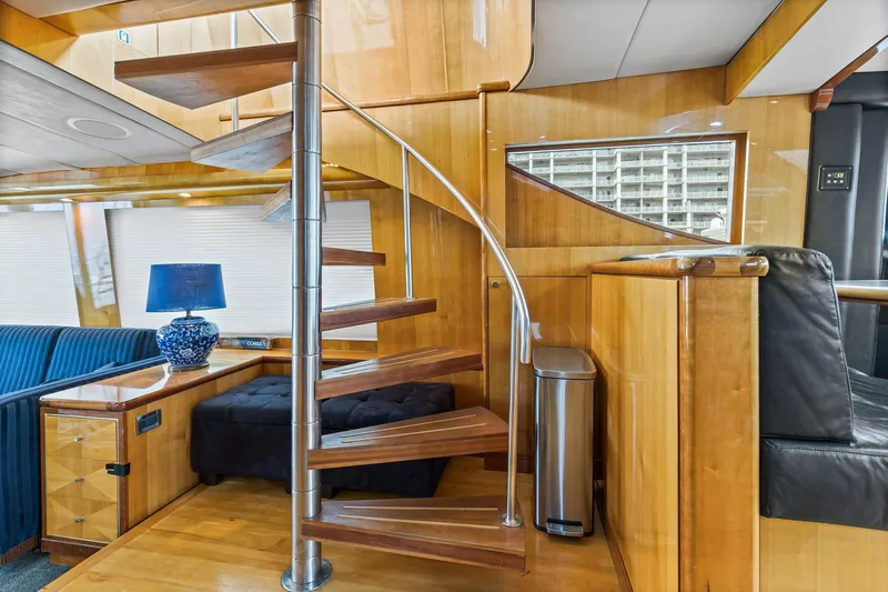 Yacht Photos Pics Luxurious interior of 2004 Queenship 76 Baretta yacht with spiral staircase and elegant decor.