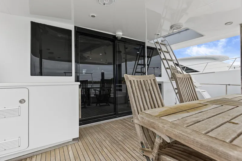  Yacht Photos Pics Luxury yacht deck with wooden furniture, glass doors, and ladder; Queenship 76 Baretta, 2004 model.