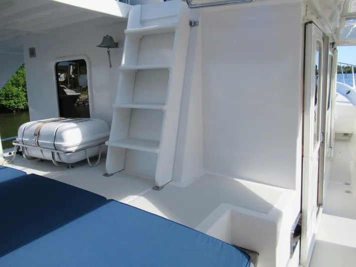 C'est La Vie Yacht Photos Pics 2010 DeFever 48 Offshore yacht deck with blue cushions and white ladder.
