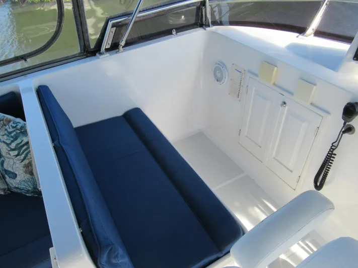 C'est La Vie Yacht Photos Pics DeFever 48 Offshore 2010 boat interior with blue cushioned seating and white cabinetry.