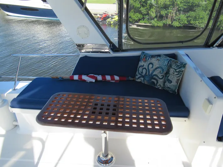 C'est La Vie Yacht Photos Pics DeFever 48 Offshore 2010 yacht interior with cushioned seating and wooden table.