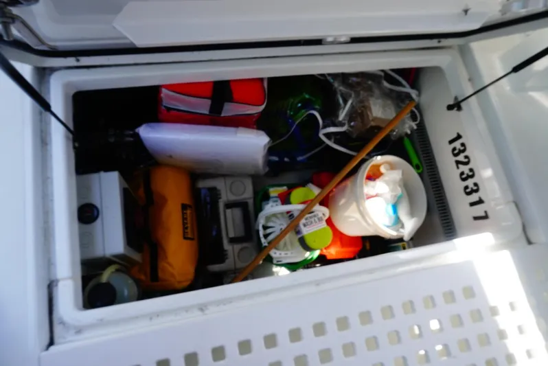 Boondoggle Yacht Photos Pics Storage compartment on 2022 Beneteau Antares 11, filled with boating equipment and supplies.